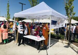 Community group under white canopy at festival