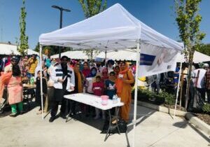 Diverse group under white canopy at outdoor festival