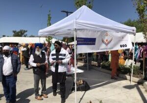 Community booth under white canopy with attendees